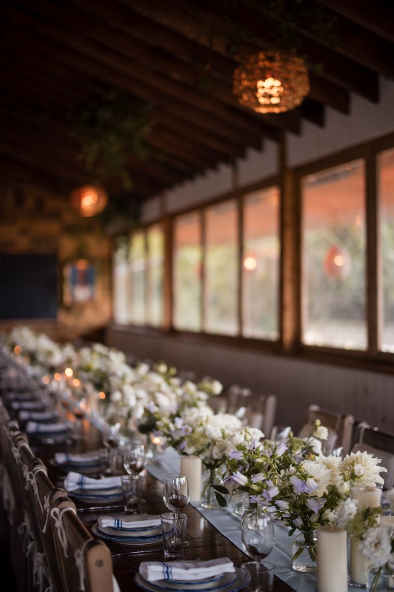 montauk wedding at Crow's Nest with a long table that has floral centerpieces, plates, and silverware