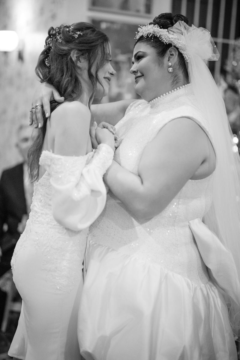 two women at their wedding reception dancing together and smiling at one another