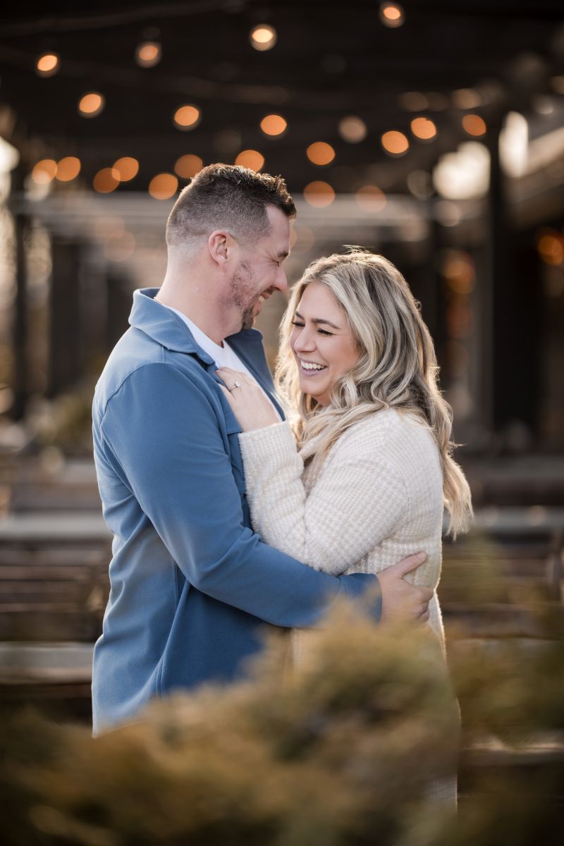 a couple standing in a cafe hugging each other and laughing