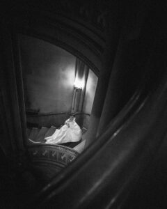 View looking down on a bride walking in a spiral staircase in a castle