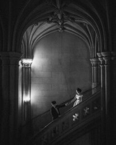 Newlywed couple holding hands and they walk on a spiral staircase