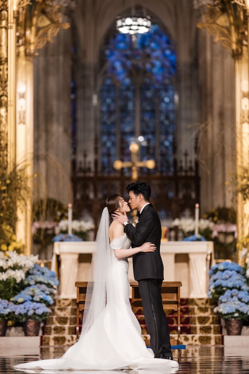 A bride and groom embrace at the altar of St. Patrick’s Cathedral