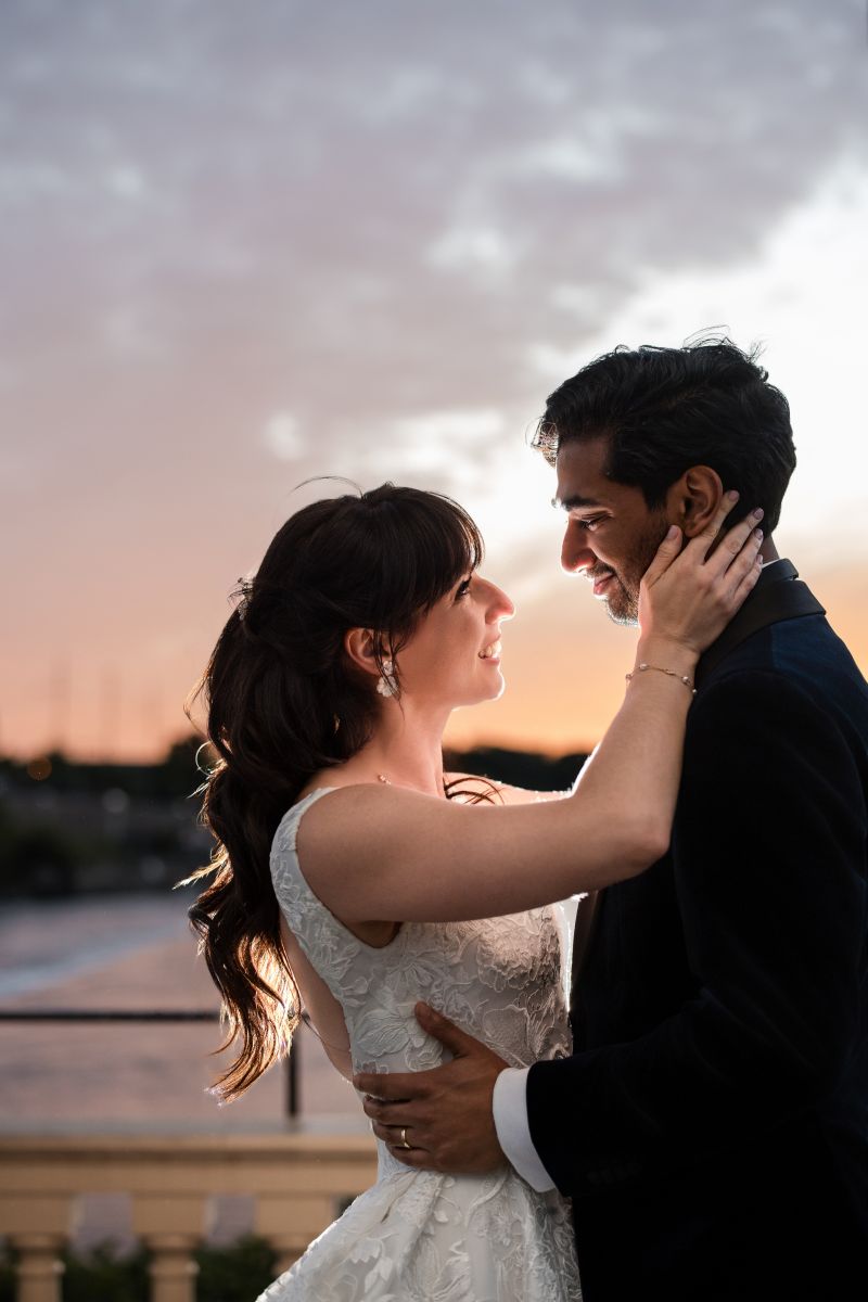A bride and groom embrace and smile at each other outdoors during sunset at their Water Works Philadelphia wedding