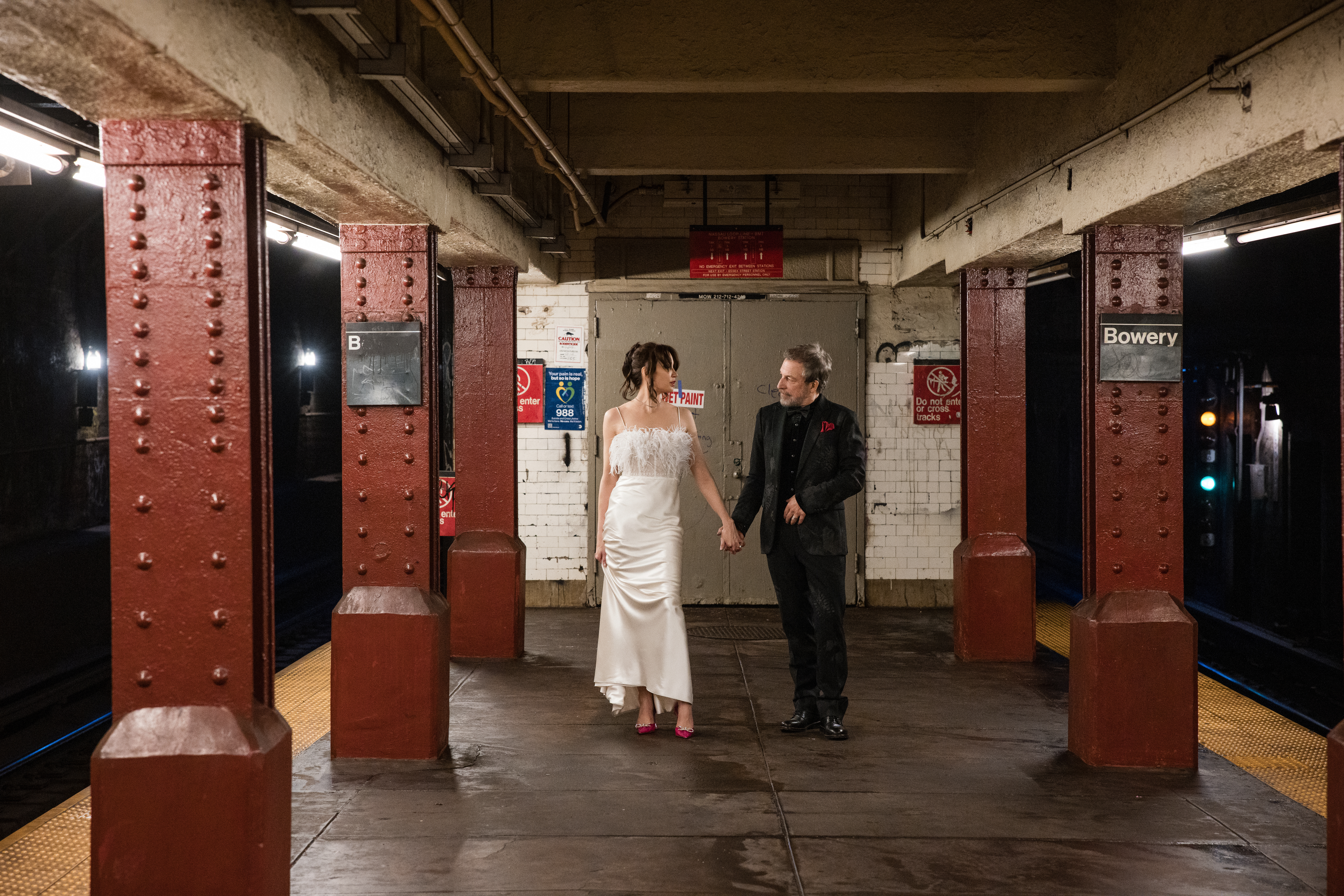 A man and woman take engagement photos on the NYC subway platform