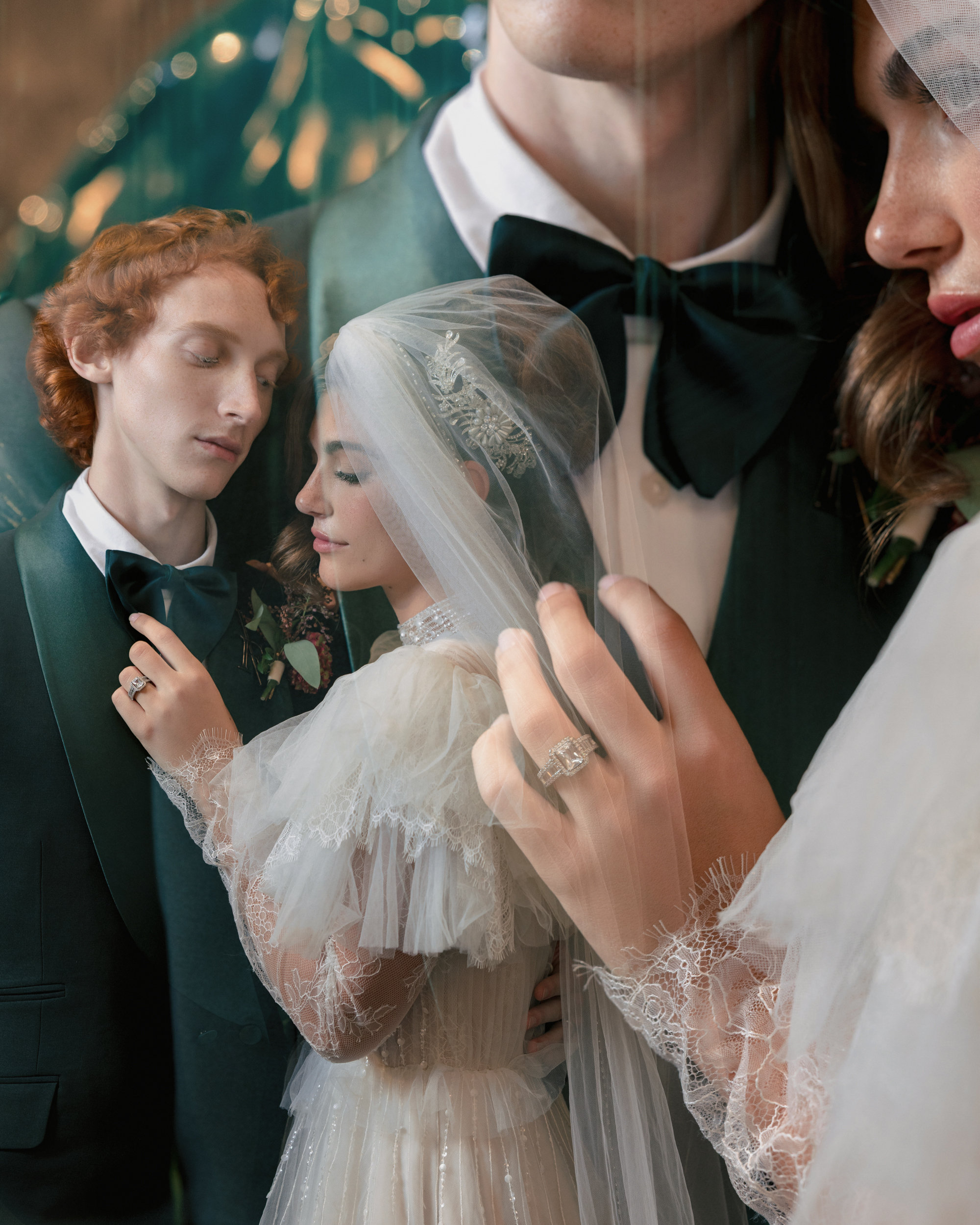 A bride and groom in formal wedding attire embrace closely, with the bride holding her veil and wearing a detailed lace dress and a prominent ring—captured in elegant Editorial Wedding Photography in NYC.