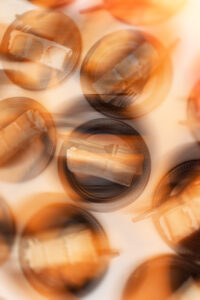 Several small black plates, each holding a slice of layered cake and a fork, are arranged on a light surface with a blurred, orange-tinted effect—perfect for capturing sweet moments at a Leoness Cellars wedding.