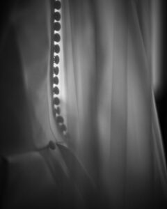 Close-up of fabric with a row of round buttons, likely part of a wedding dress or formal garment, shown in soft black and white lighting—capturing the elegance of a Downtown Club Philadelphia Wedding.
