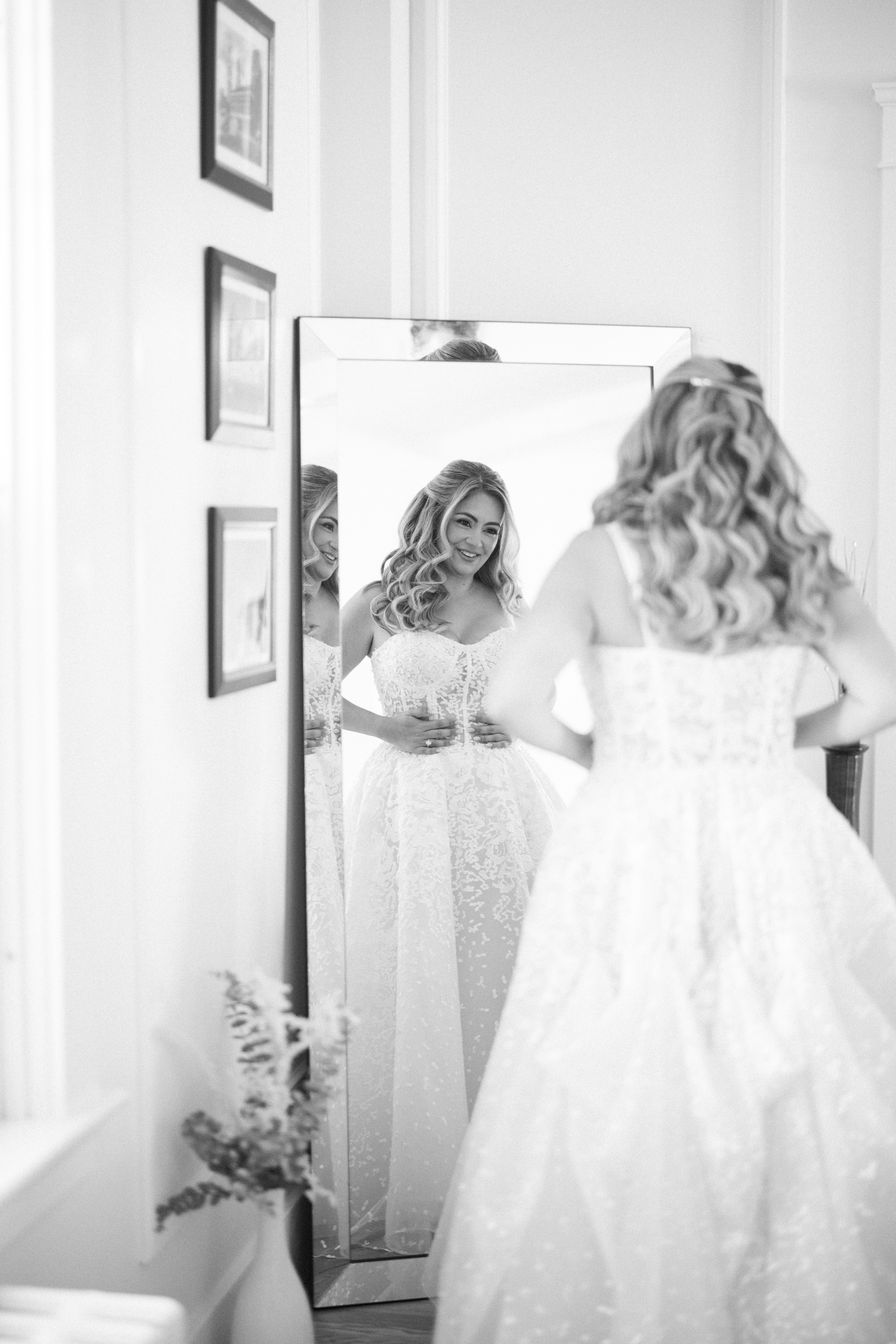 A bride looks at herself in a mirror before her Regatta Place wedding