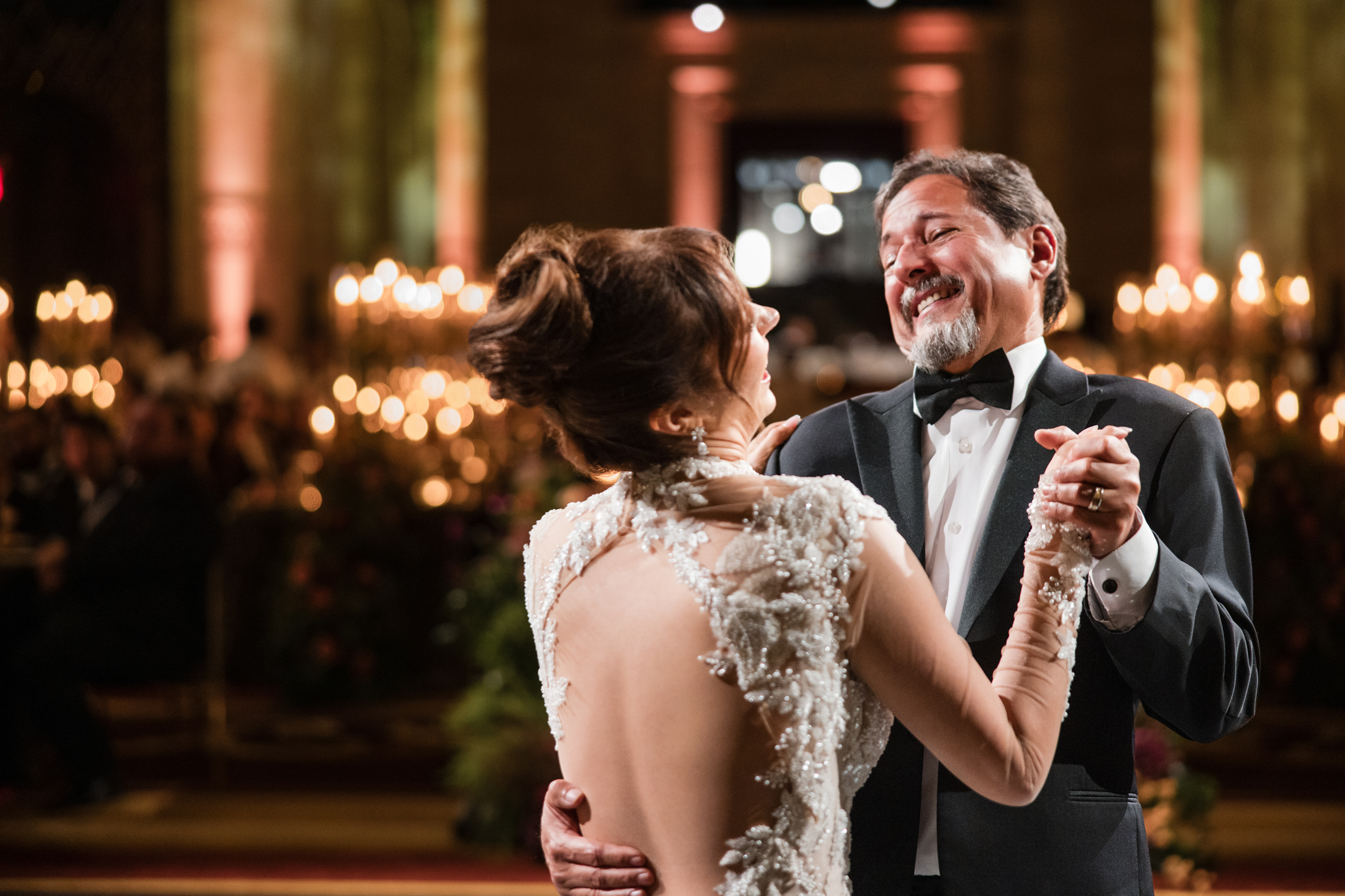 A bride in an embellished backless gown dances with her father in a tuxedo at a Cipriani 25 Broadway wedding. A bride in an embellished backless gown dances with her father in a tuxedo at a Cipriani 25 Broadway wedding.